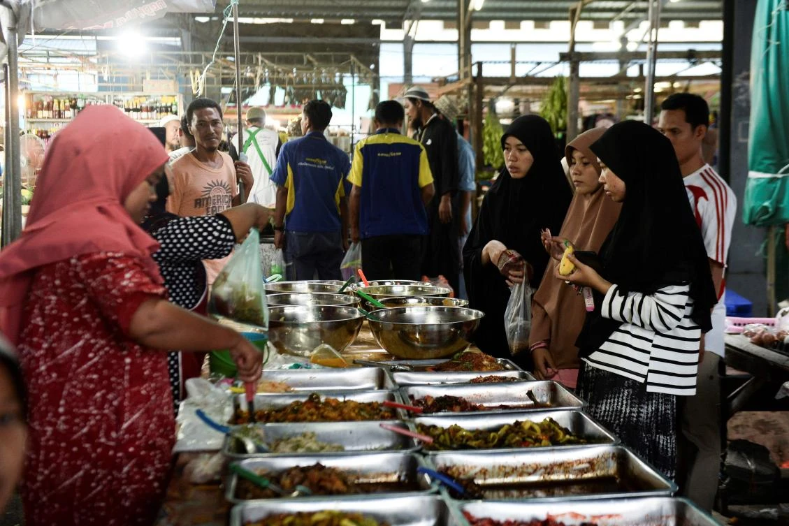 Thai Muslims buy food items at a market prior to breaking their fast during the holy month of Ramadan in Narathiwat on May 7, 2019. Muslims around the world abstain from eating, drinking and conducting sexual relations from sunrise to sunset during Ramadan, the holiest month in the Islamic calendar. / AFP / Madaree TOHLALA