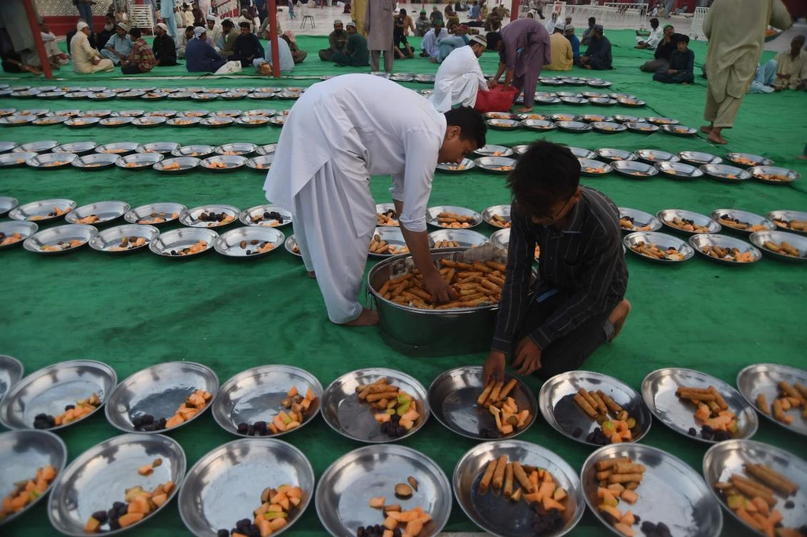 A Pakistani volunteer prepares Iftar food for Muslim devotees prior to breaking their fast on the first day of the holy month of Ramadan at a mosque in Karachi on May 7, 2019. Muslims throughout the world are marking the month of Ramadan, the holiest month in the Islamic calendar during which Muslims fast from dawn until dusk. / AFP / ASIF HASSAN