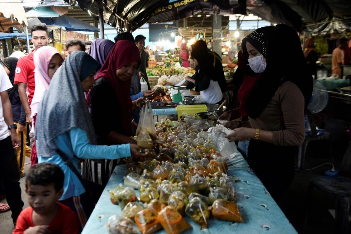 Thai Muslims buy food items at a market prior to breaking their fast during the holy month of Ramadan in Narathiwat on May 7, 2019. Muslims around the world abstain from eating, drinking and conducting sexual relations from sunrise to sunset during Ramadan, the holiest month in the Islamic calendar. / AFP / Madaree TOHLALA