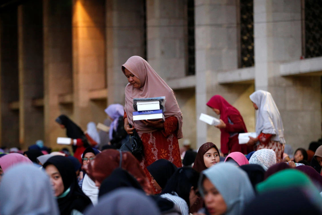 Indonesian Muslim women carry boxes of food for iftar during the holy month of Ramadan at Istiqlal mosque in Jakarta, Indonesia, May 7, 2019. REUTERS/Willy Kurniawan