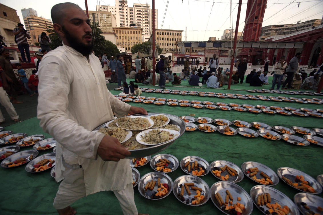 A volunteer arranges food for the "Iftar" meal for Muslims to break their fast at sundown, during the fasting month of Ramadan at a mosque in Karachi Pakistan, Tuesday, May 7, 2019. Muslims around the world are observing Ramadan, the holiest month in Islamic calendar. (AP Photo/Fareed Khan)