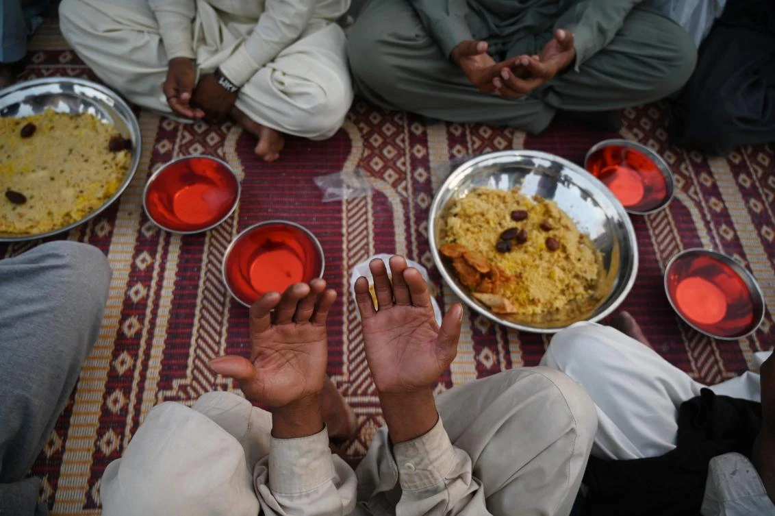 Pakistani Muslims offer prayers prior to breaking their fast on the first day of the holy month of Ramadan along the roadside in Rawalpindi on May 7, 2019. Muslims throughout the world are marking the month of Ramadan, the holiest month in the Islamic calendar during which Muslims fast from dawn until dusk. / AFP / AAMIR QURESHI