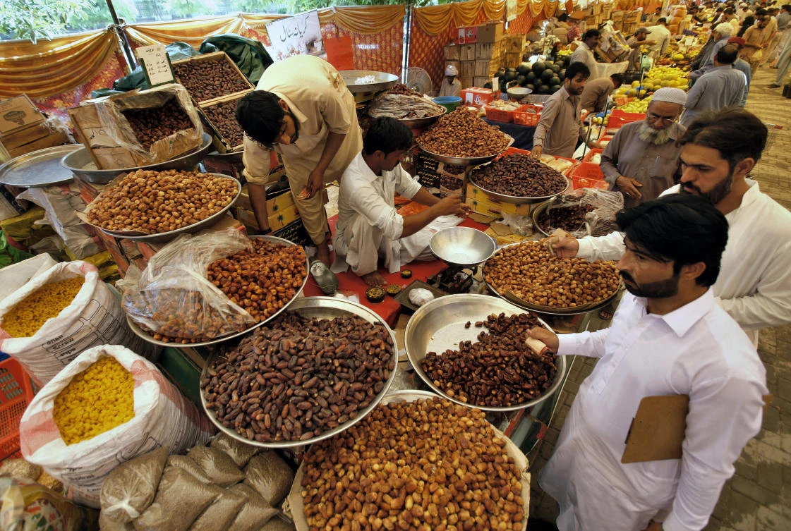Pakistani Muslims buy dates, a favorite food for Muslims for 'iftar', the meal to break their fast, from a government-run bazaar specially set up for fasting month of Ramadan, in Rawalpindi, Pakistan, Tuesday, May 7, 2019. Muslims around the world are observing Ramadan, the holiest month in Islamic calendar. (AP Photo/Anjum Naveed)