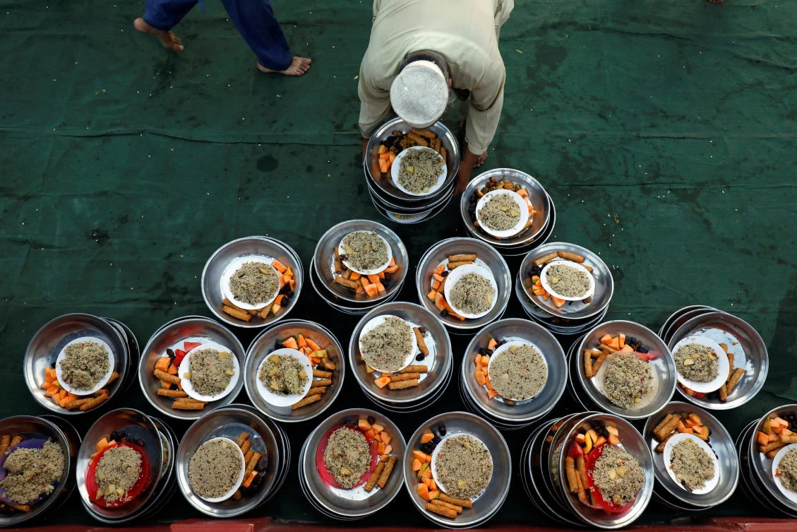 A volunteer arranges food plates for the people to break fast during the fasting month of Ramadan at a mosque in Karachi, Pakistan, May 7, 2019. REUTERS/Akhtar Soomro