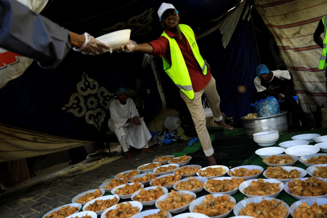 Sudanese volunteers prepare meals for protesters during the Muslim fasting month of Ramadan in front of the defense ministry compound in Khartoum, Sudan, May 7, 2019. REUTERS/Umit Bektas