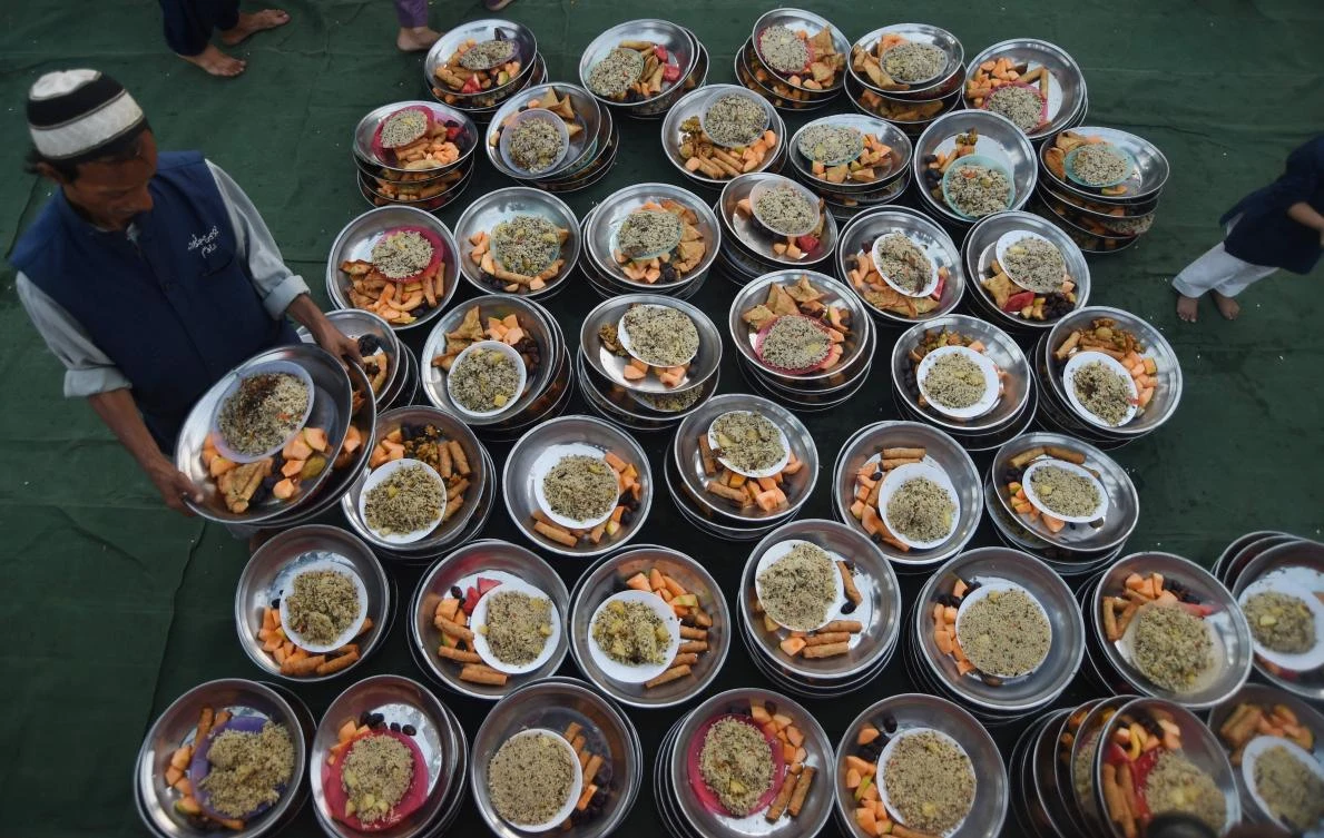 A Pakistani volunteer prepares Iftar food for Muslim devotees prior to breaking their fast on the first day of the holy month of Ramadan at a mosque in Karachi on May 7, 2019. Muslims throughout the world are marking the month of Ramadan, the holiest month in the Islamic calendar during which Muslims fast from dawn until dusk. / AFP / ASIF HASSAN