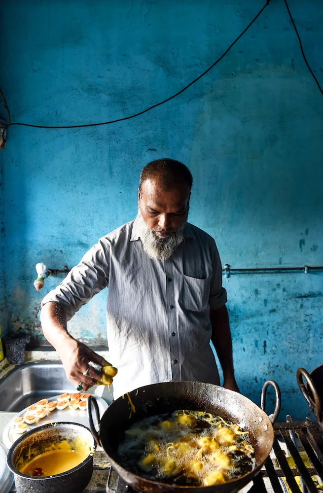 Indian cook Adil Ahmad prepares egg bhajias (fried eggs wrapped with potato and chickpea batter), during the holy month of Ramadan in Ahmedabad on May 18, 2019. (AFP)