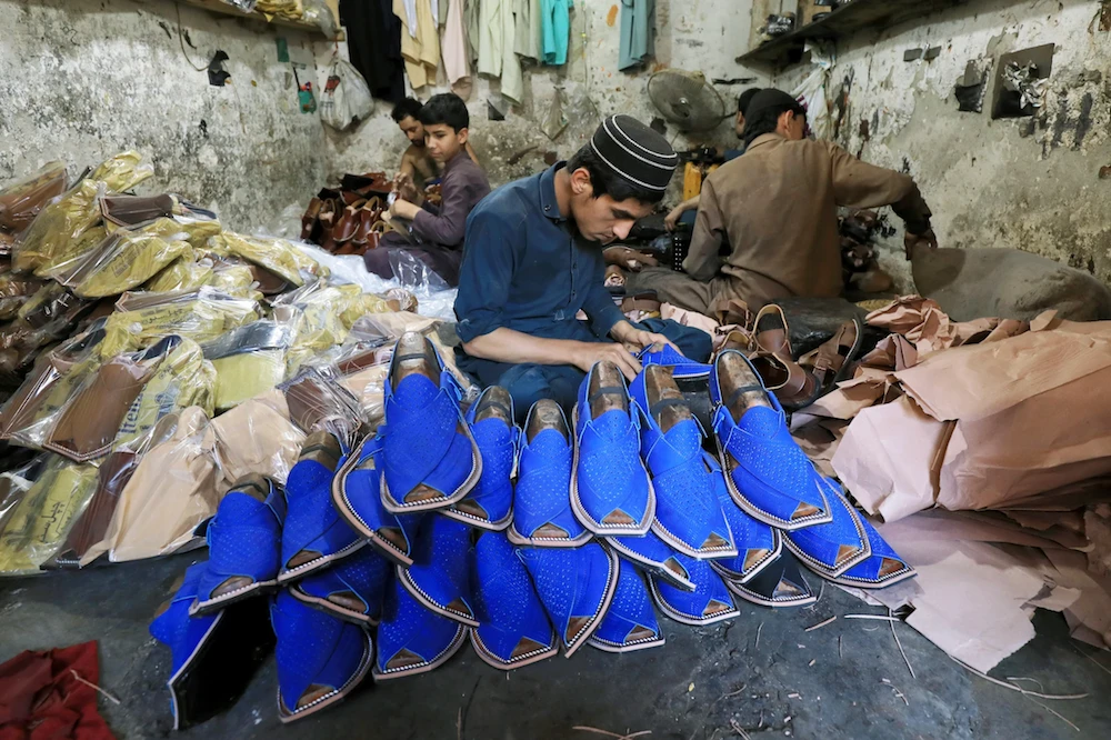 People are seen at a workshop as they are prepare traditional sandals to sell, ahead of Muslim holiday of Eid al-Fitr, in Peshawar, Pakistan May 20, 2019. (Reuters)