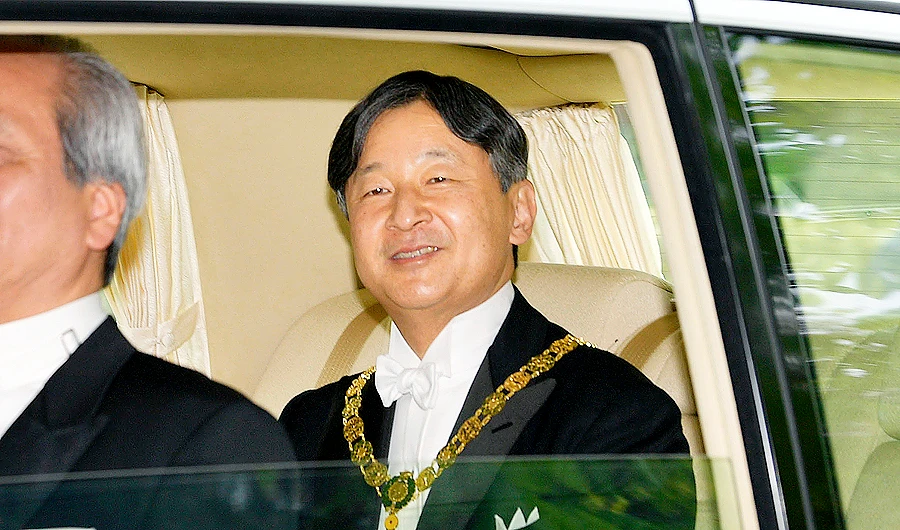 From a car window on his way to palace, Naruhito smiled and waved at the people on the sidewalk who cheered him. (AP)