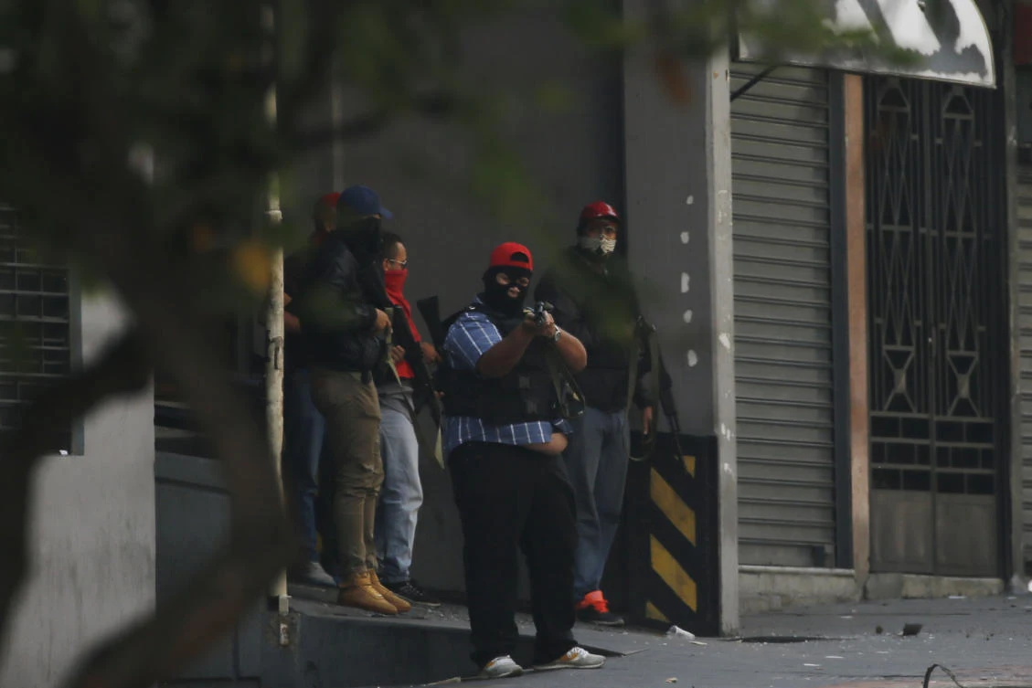 Armed and masked supporters of President Nicolas Maduro stand at an entrance of the Transportation Ministry in Caracas, Venezuela, Tuesday, April 30, 2019, during a military uprising attempt to oust Maduro. (AP/Fernando Llano)