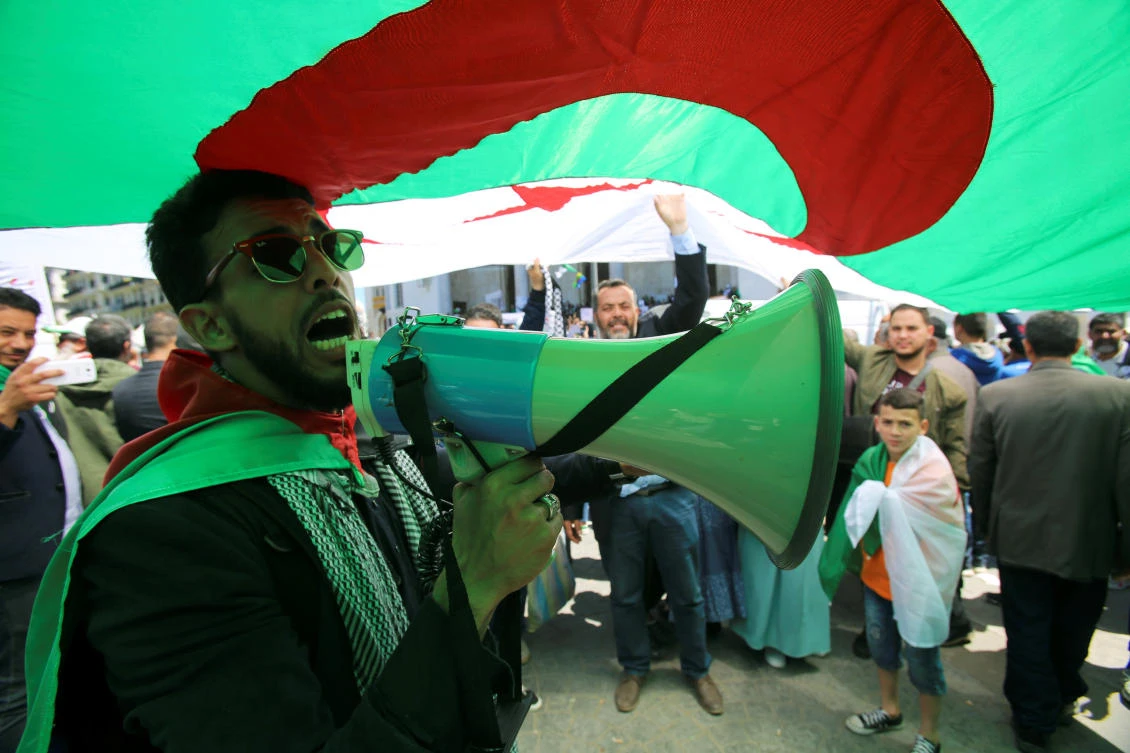 A demonstrator uses a bullhorn to shout protest slogans during a May Day march on Labour Day in Algiers, Algeria, May 1, 2019. (Reuters)