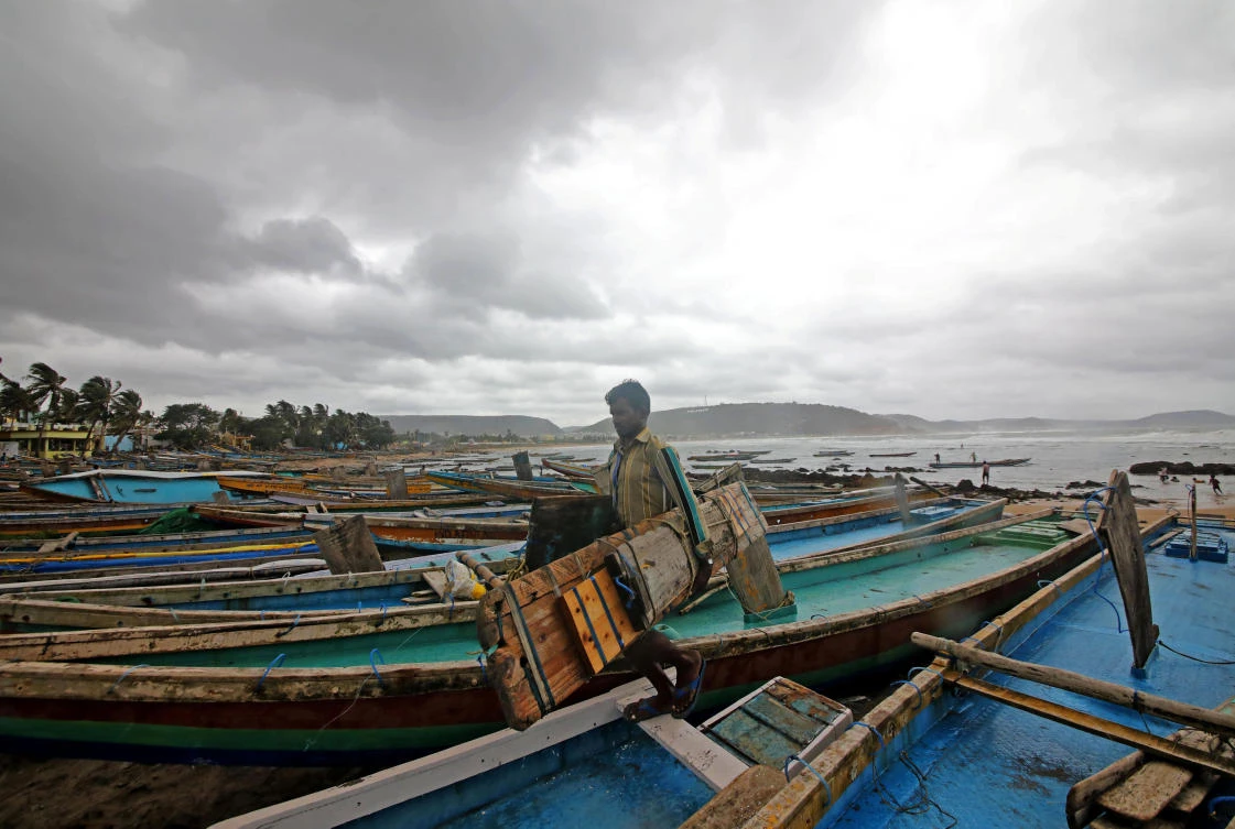 A fisherman carries his tools as he leaves for a safer place after tying his boats along the shore ahead of Cyclone Fani in Peda Jalaripeta on the outskirts of Visakhapatnam, India. (Reuters)