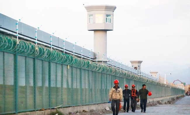 Workers walk by the perimeter fence of what is officially known as a vocational skills education centre in Dabancheng in Xinjiang Uighur Autonomous Region, China September 4, 2018. (REUTERS)