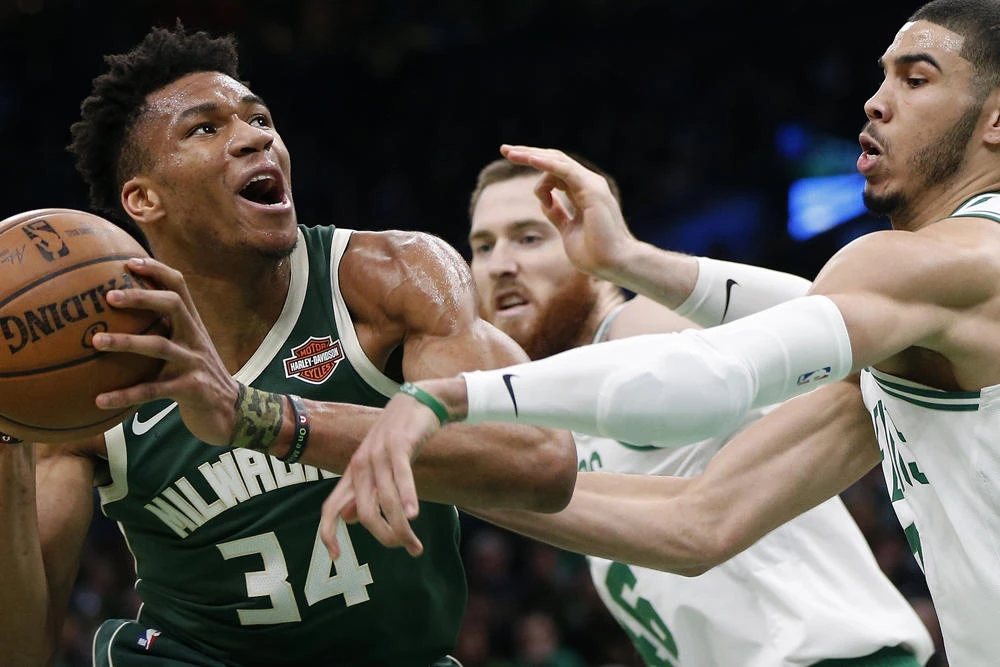 Boston Celtics' Jayson Tatum, right, and Aron Baynes, behind, double-team Milwaukee Bucks' Giannis Antetokounmpo (34) during the first half of Game 3 of a second round NBA basketball playoff series in Boston on May 3, 2019. (AP Photo/Michael Dwyer)