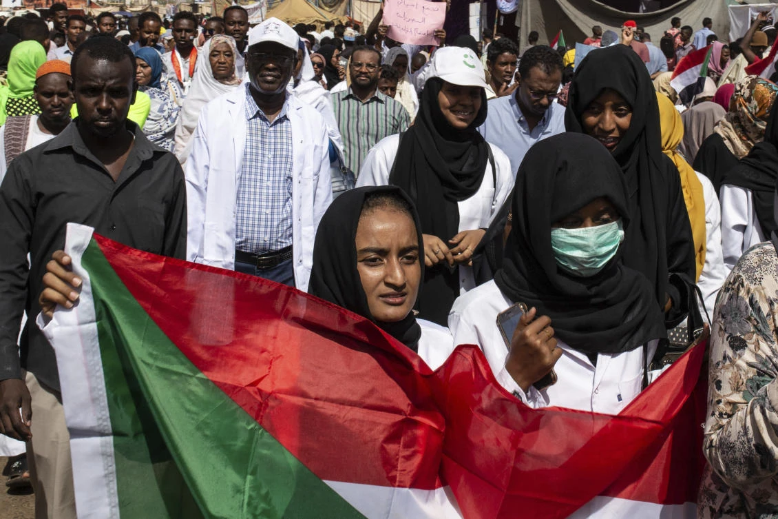 A protester carries a Sudanese flag as they chant against military rule and demand the prosecution of former officials, at the Armed Forces Square, in Khartoum, Sudan, Sunday April 28, 2019. (AP)