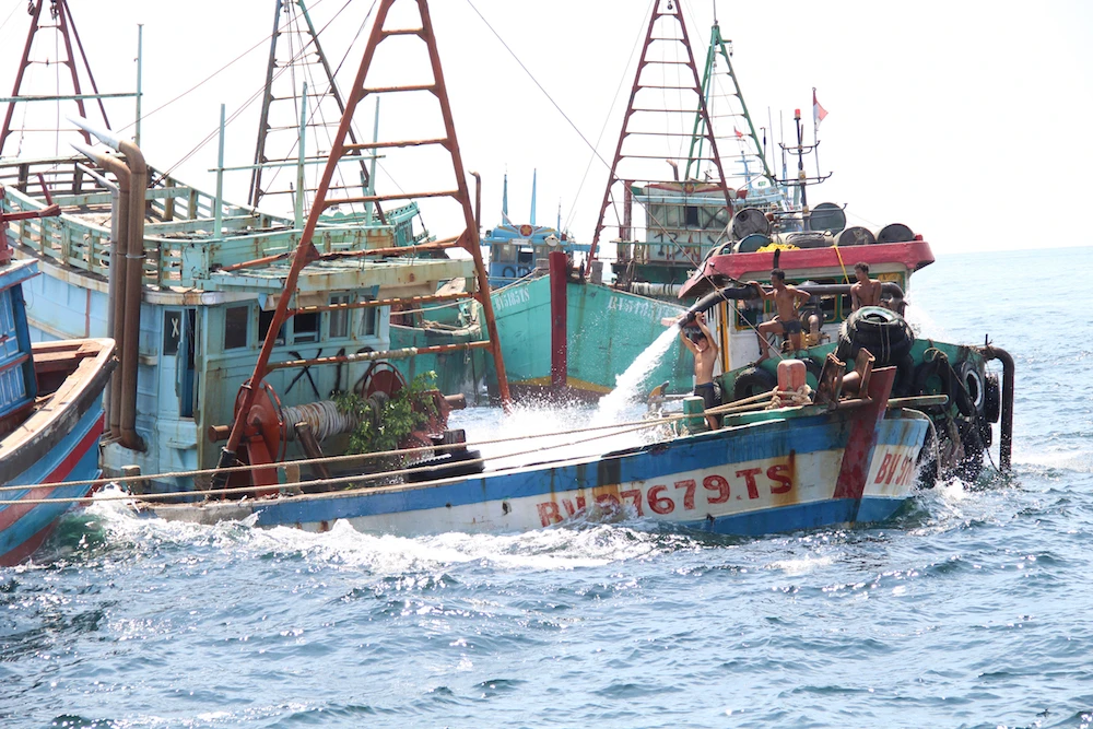 Workers flood the cargo bay of a Vietnamese-flagged boats with water to sink it in the waters off Datuk Island, West Kalimantan, Indonesia, Saturday, May 4, 2019. (AP)