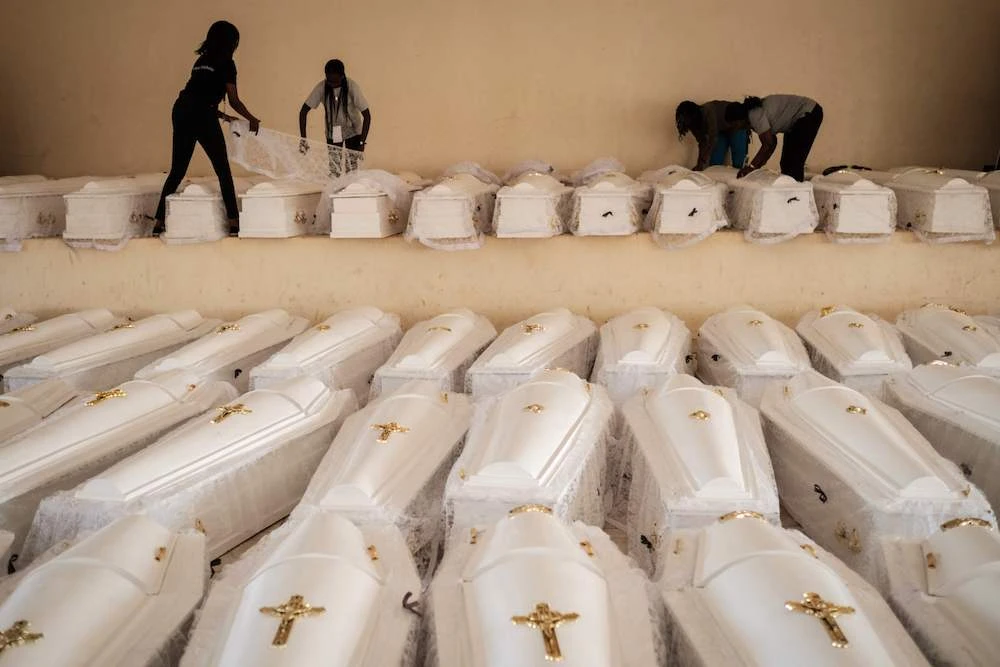 People prepare coffins containing newly discovered remains of 84,437 victims of the 1994 genocide before a funeral ceremony at the Nyanza Genocide Memorial, suburb of the capital Kigali, on May 4, 2019. (AFP)