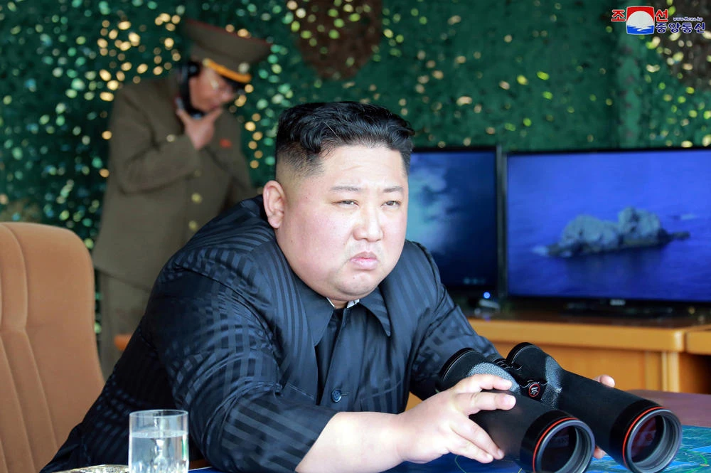 North Korean leader Kim Jong Un, equipped with binoculars, observing tests of different weapons systems, in North Korea on May 4, 2019. (Korean Central News Agency/Korea News Service via AP)