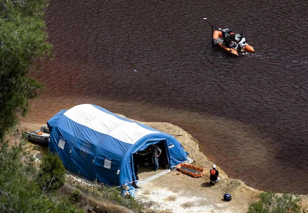 A boat equipped with a sonar system sails on the acidic Red Lake near the village of Mitsero, southwest of the capital Nicosia, during the search for possible bodies of victims of a suspected serial killer, on May 4, 2019. (AFP)