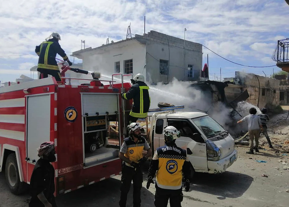 Civil defense workers extinguishing damaged shops after shelling hit a street in the town of Ehssem, southern Idlib, Syria, on Friday. A hospital was struck in the area on Sunday. (Syrian Civil Defense White Helmets via AP)
