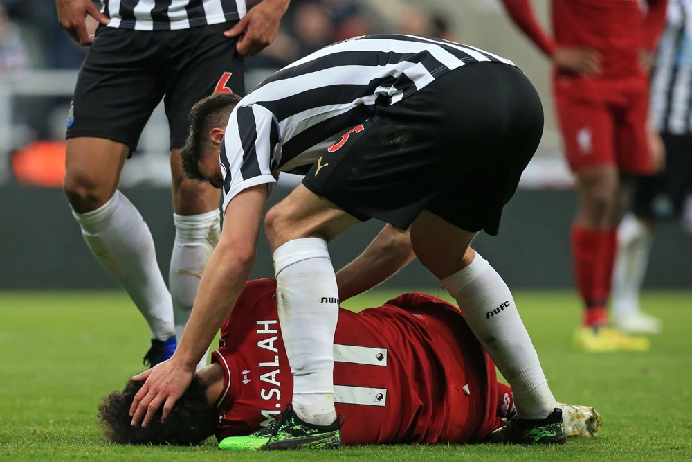 Newcastle United's Swiss defender Fabian Schar attends to Liverpool's Egyptian midfielder Mohamed Salah who injured himself during the English Premier League football match between Newcastle United and Liverpool in Newcastle-upon-Tyne on May 4, 2019. (AFP / Lindsey Parnaby)