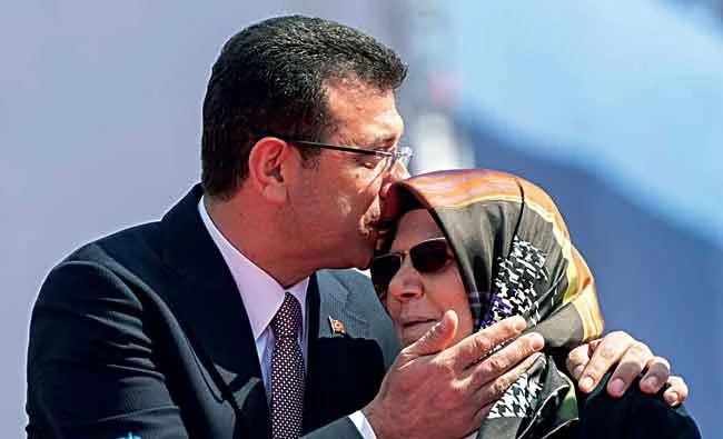 Mayor of Istanbul Ekrem Imamoglu kisses his mother Hava Imamoglu during a rally in Istanbul. (AFP)