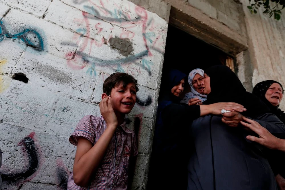 Relatives at the Monday funeral of five Palestinians, who were killed in Israeli strikes the previous day, in Beit Lahia, in northern Gaza strip. (AFP)
