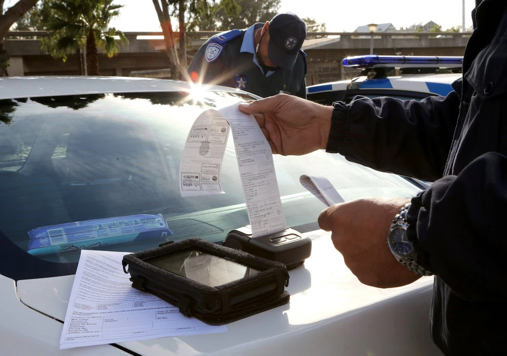 A traffic officer prints out a fine for an Uber driver who operates without a permit in Cape Town, South Africa, May 4, 2019. (Reuters)