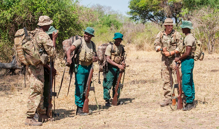 In this file photo taken on October 14, 2017 British Trooper and Counter Poaching Operator Samuel Knuckey (2nd R) and Malawian born British soldier Sergeant and Counter Poachinh Operator Kingsley Kachoka (L) speak with participants after taking them through a demonstration of field tactics for countering poachers during Counter Poaching Training course for Game Rangers at the Liwonde National Park in Machinga District South Eastern Malawi. (AFP)