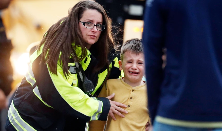 Officials guide students off a bus and into a recreation center where they were reunited with their parents after a shooting at a suburban Denver middle school Tuesday, May 7, 2019, in Highlands Ranch, Colo. (AP)