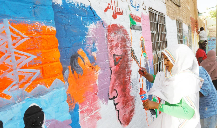Amna Almahi works on a mural near the defence ministry compound in Khartoum, Sudan, April 22, 2019. (REUTERS)
