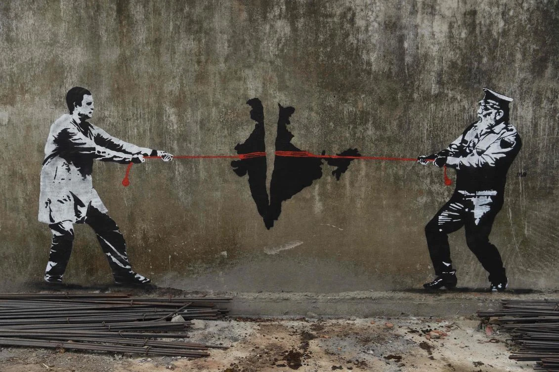 A wall graffiti depicting Indian National Congress (INC) party leader Rahul Gandhi (L) and Prime Minister Narendra Modi of Bharatiya Janata Party (BJP) in a tug of war over India is seen in Mumbai on April 28, 2019. (AFP)