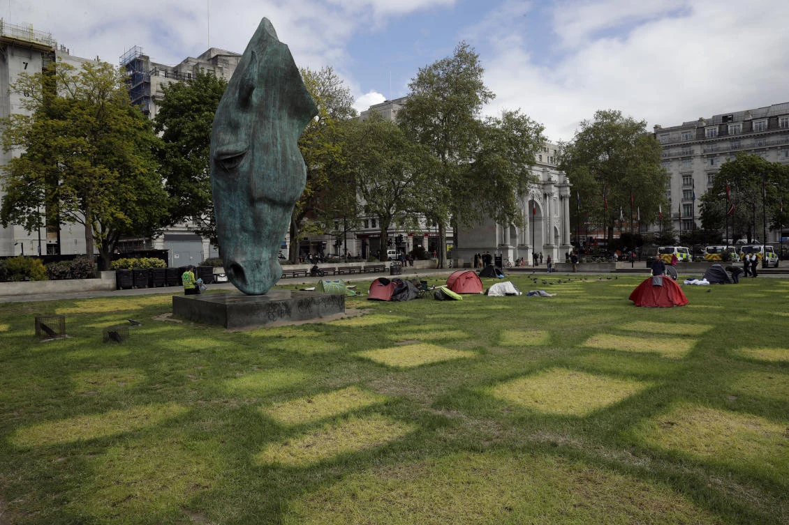 The horse’s head sculpture “Still Water” by Nic Fiddian-Green stands next to tent marks outlined on grass from where Extinction Rebellion climate protesters had set up a camp in Marble Arch, London, remaining tents were being collected up and redistributed for charity, Friday, April 26, 2019. (AP)