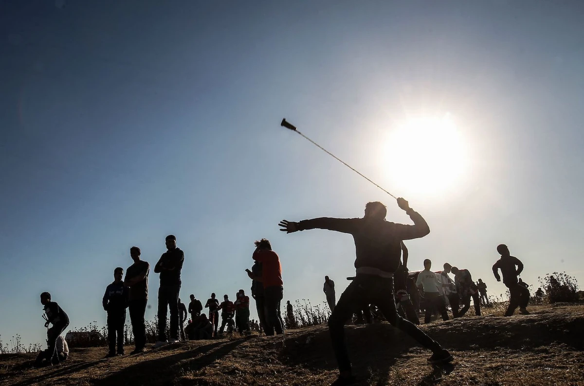 A Palestinian protester hurls stones at Israeli troops during a demonstration near the border with Israel, east of Gaza City, on May 10, 2019. (AFP)