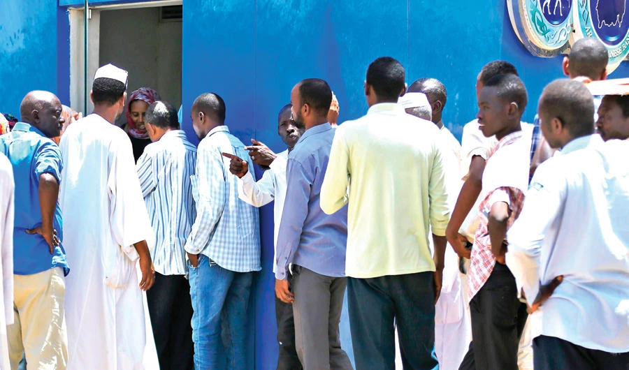 Sudanese people queue up at an ATM in Khartoum on Thursday as a deep economic crisis sparks months of protests in the North African country. (AFP)