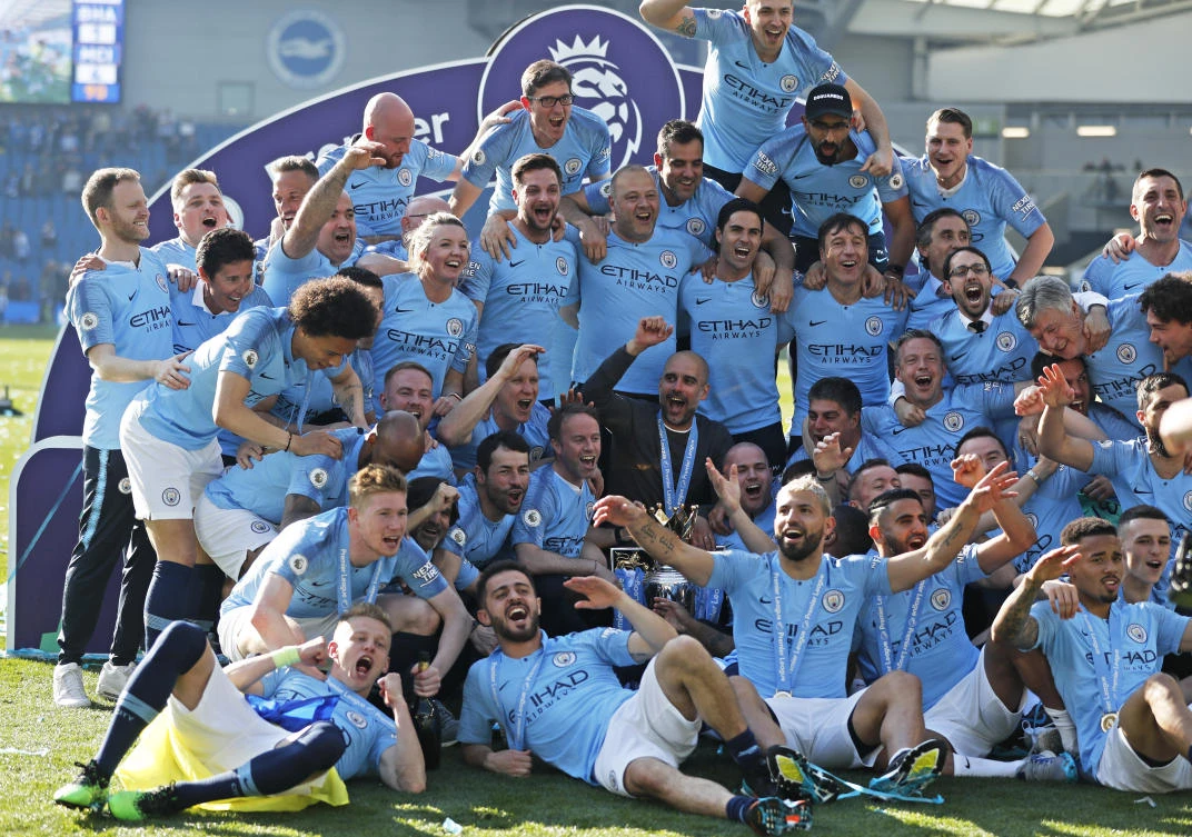 Manchester City coach Pep Guardiola, center, celebrates with players and staff after the Premier League match between Brighton and City at the AMEX Stadium in Brighton. (AP)
