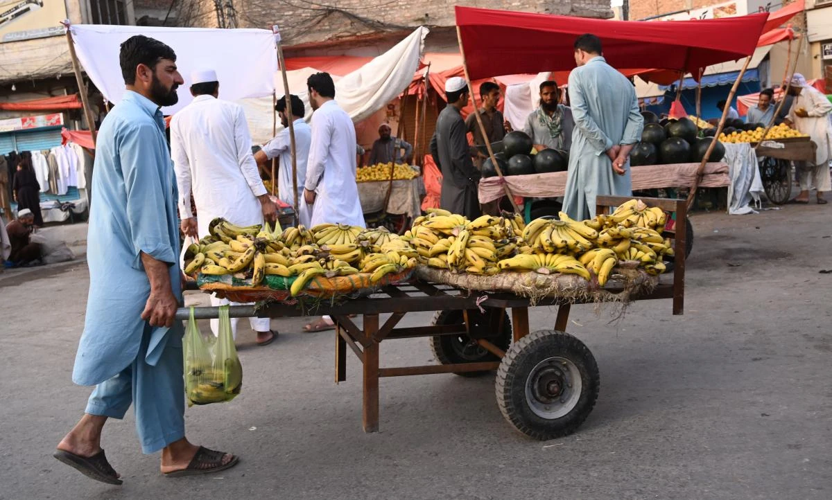A Pakistani vendor sells bananas along a street in Rawalpindi. Pakistan's growth rate is set to hit an eight-year low, a government report predicted on May 10, with all major indicators down as the country continues negotiating its 22nd bailout from the IMF. (AFP)