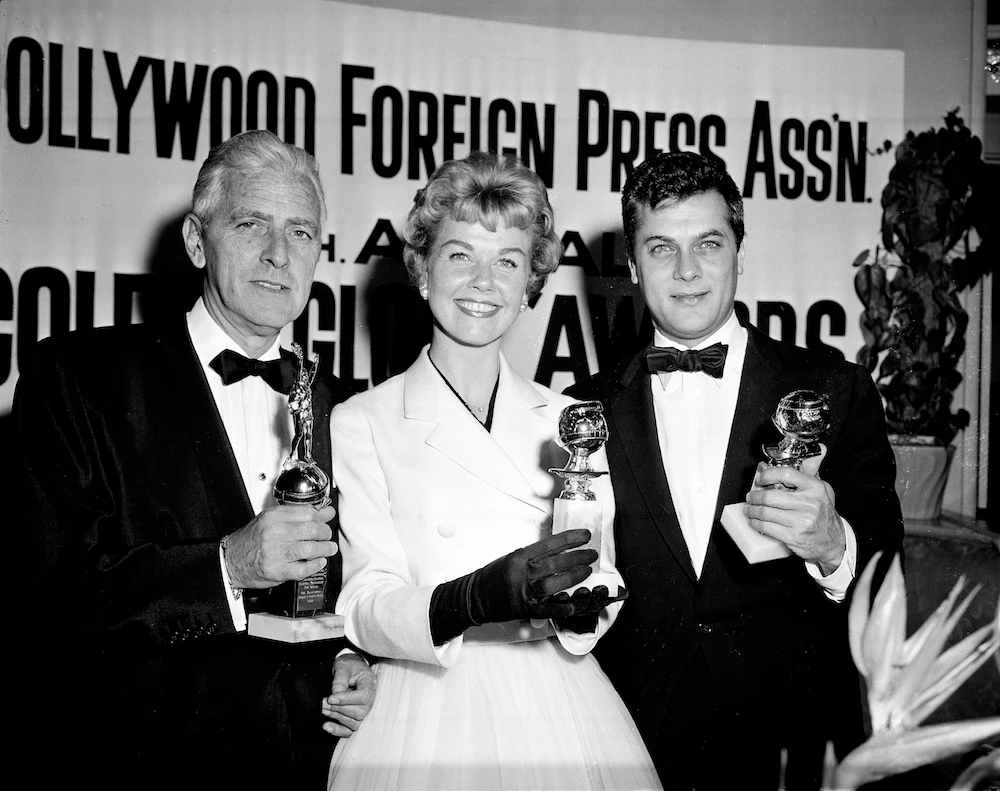 Actress Doris Day (C) Tony Curtis (R) and Buddy Adler pose with their awards presented to them by the Hollywood Foreign Press Association at its annual awards dinner in the Cocoanut Grove in Los Angeles. (File/AP)