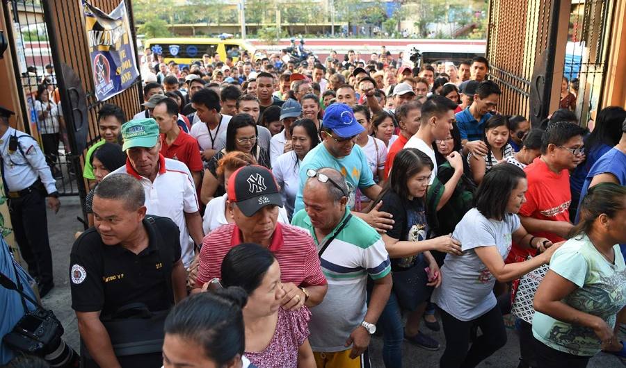 Voters rush inside as the gate opens at a polling precinct in Manila on Monday. (AFP)
