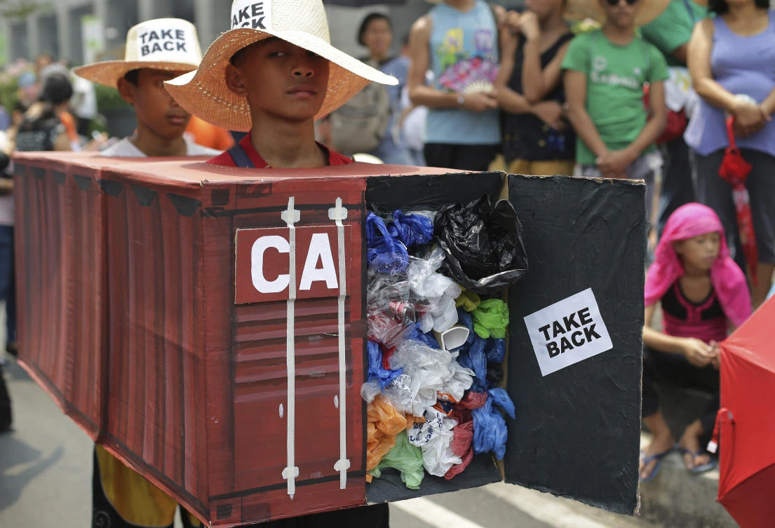 An environmental activist wear a mock container vans filled with garbage shipped from Canada as they hold a protest outside the Canadian embassy on May 7, 2015. (AP)
