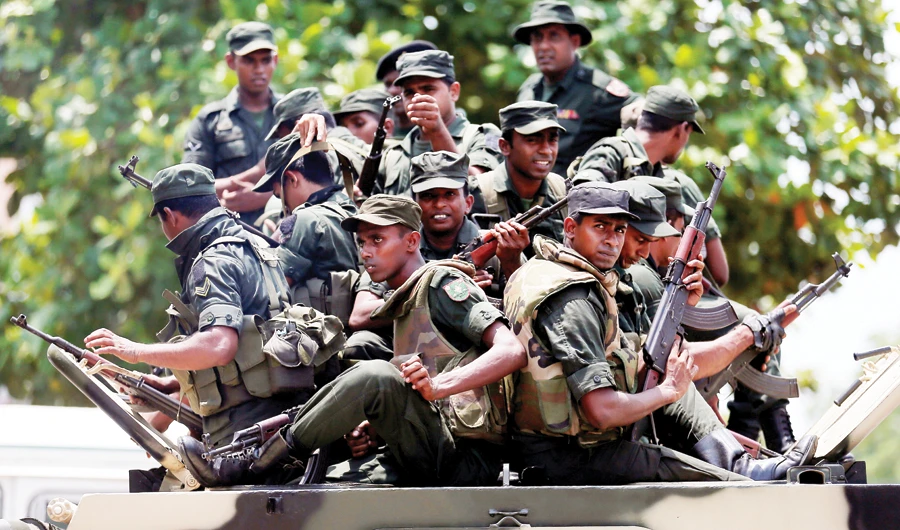 Sri Lankan soldiers patrol a road in the North Western Province on top of an armored vehicle to prevent fresh mob violence in the region. (FIle/Reuters)
