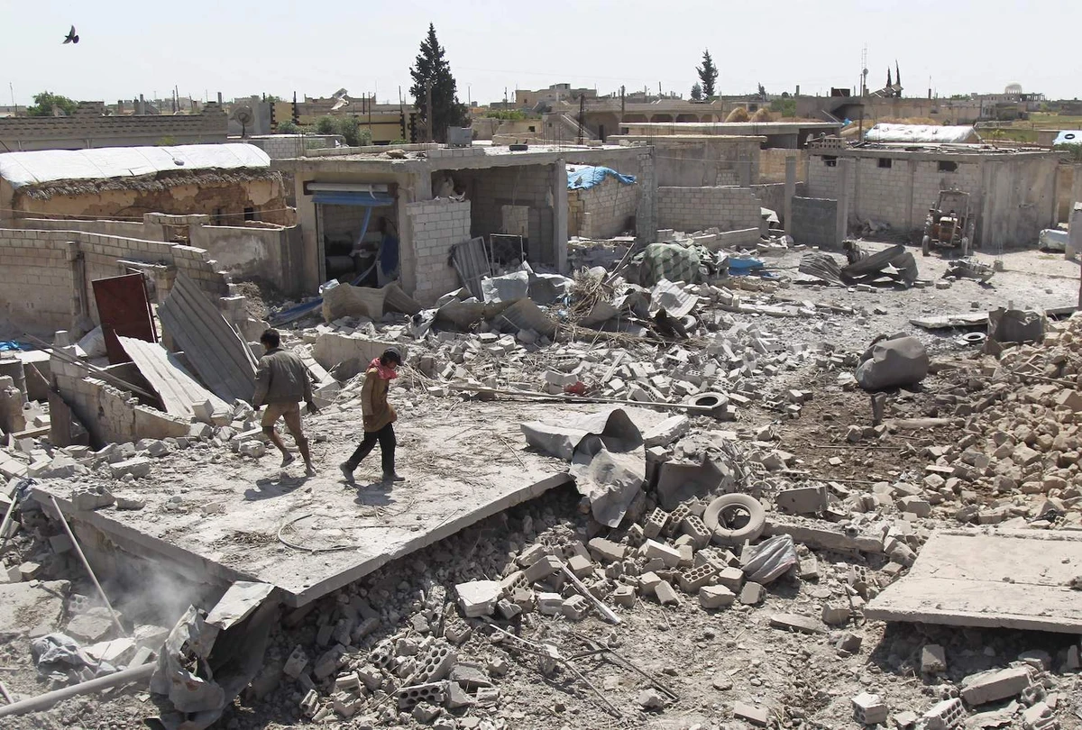 Men walk among the rubble of a building that was destroyed during airstrikes by the Syrian regime and their allies near the town of Saraqeb in Syria's rebel-held northwestern province of Idlib on May 7, 2019. (AFP)