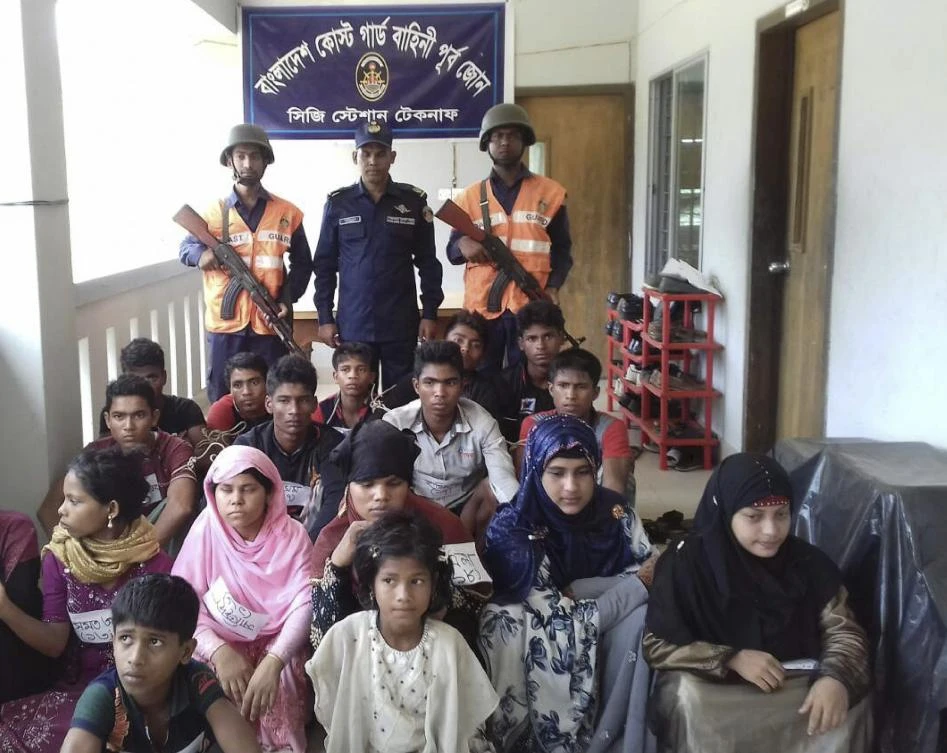 Bangladesh Coast Guard pose for a photo with rescued Rohingya refugees in Teknaf on May 18, 2019. (AFP)