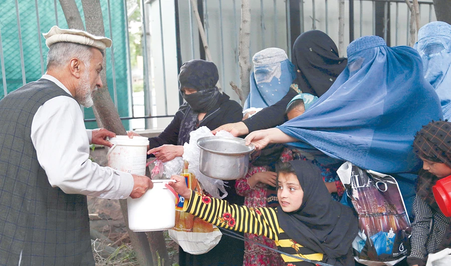 Afghan families receive free food donated by other citizens as they prepare to break their fast during the holy month of Ramadan, in Kabul. (AP )