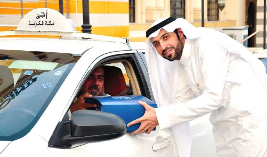 A cab driver at Four Points by Sheraton Makkah receives an iftar pack from the hotel staff.