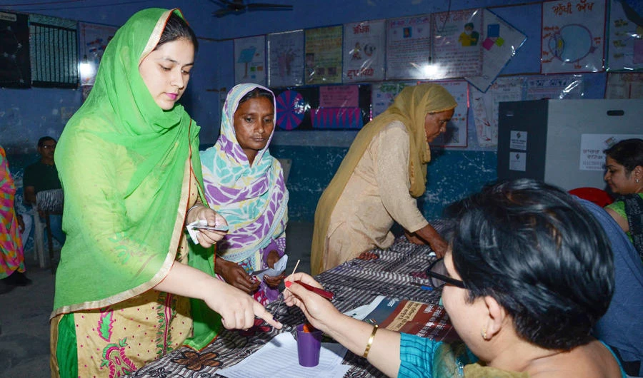 An Indian election officer (R) marks the finger of a voter at a polling centre on the outskirts of Amritsar on May 19, 2019, during the 7th and final phase of India's general election. (AFP)