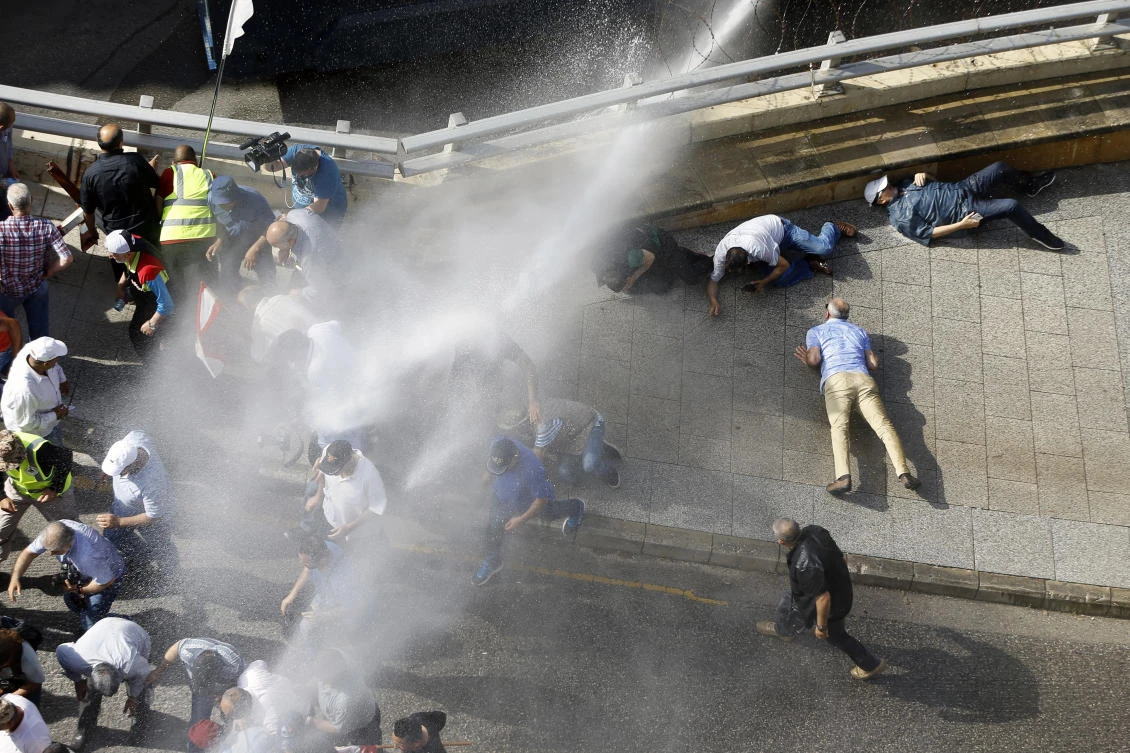 Retired Lebanese soldiers lay on the ground as police using water cannons during a protest in Beirut Monday. (AP)