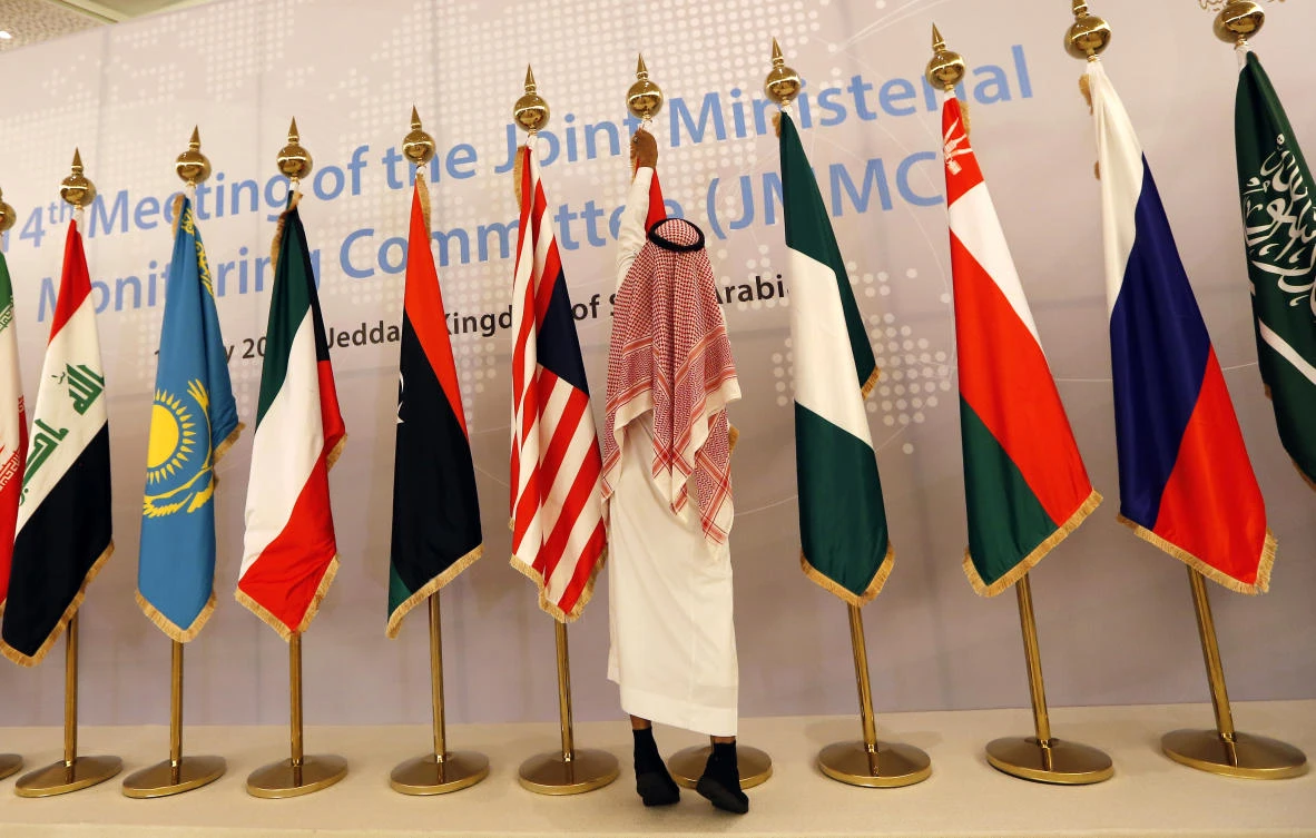 A worker adjusts flags of participating countries before a meeting of energy ministers from OPEC and its allies in Jeddah, Saudi Arabia on May 19, 2019. (AP)