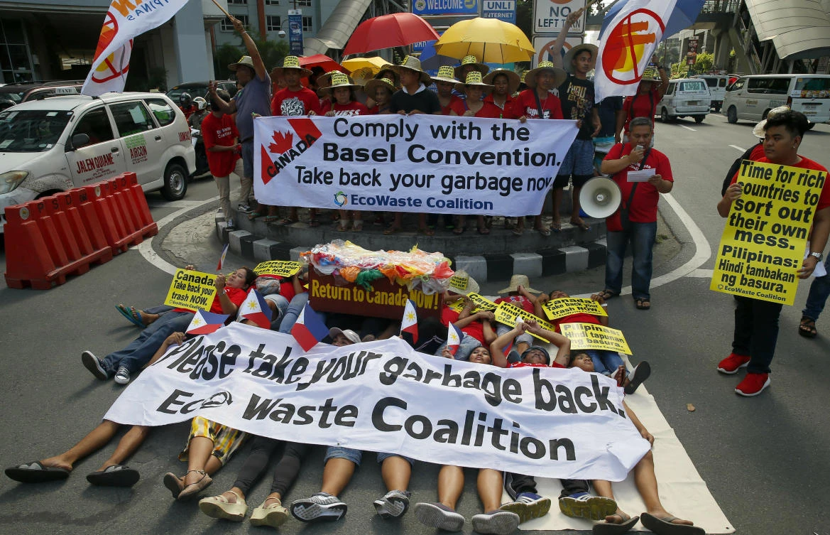 Environmentalists stage a die-in protest outside the Canadian embassy to demand the Canadian government to speed up the removal of several containers of garbage that were shipped to the Philippines (AP)