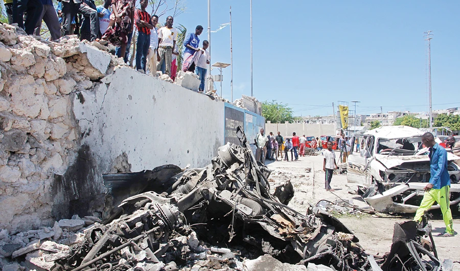 Somalis look at the wreckage after a suicide car bomb attack in Mogadishu, Somalia on Wednesday. (AP)